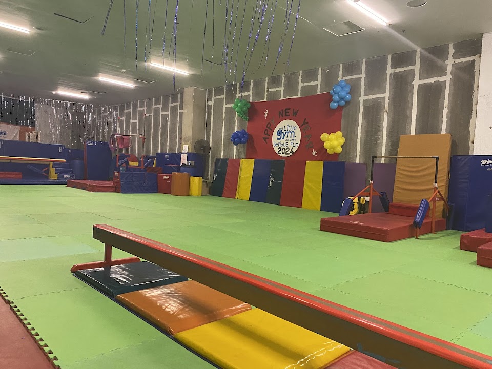 Children walking on a padded balance beam at The Little Gym